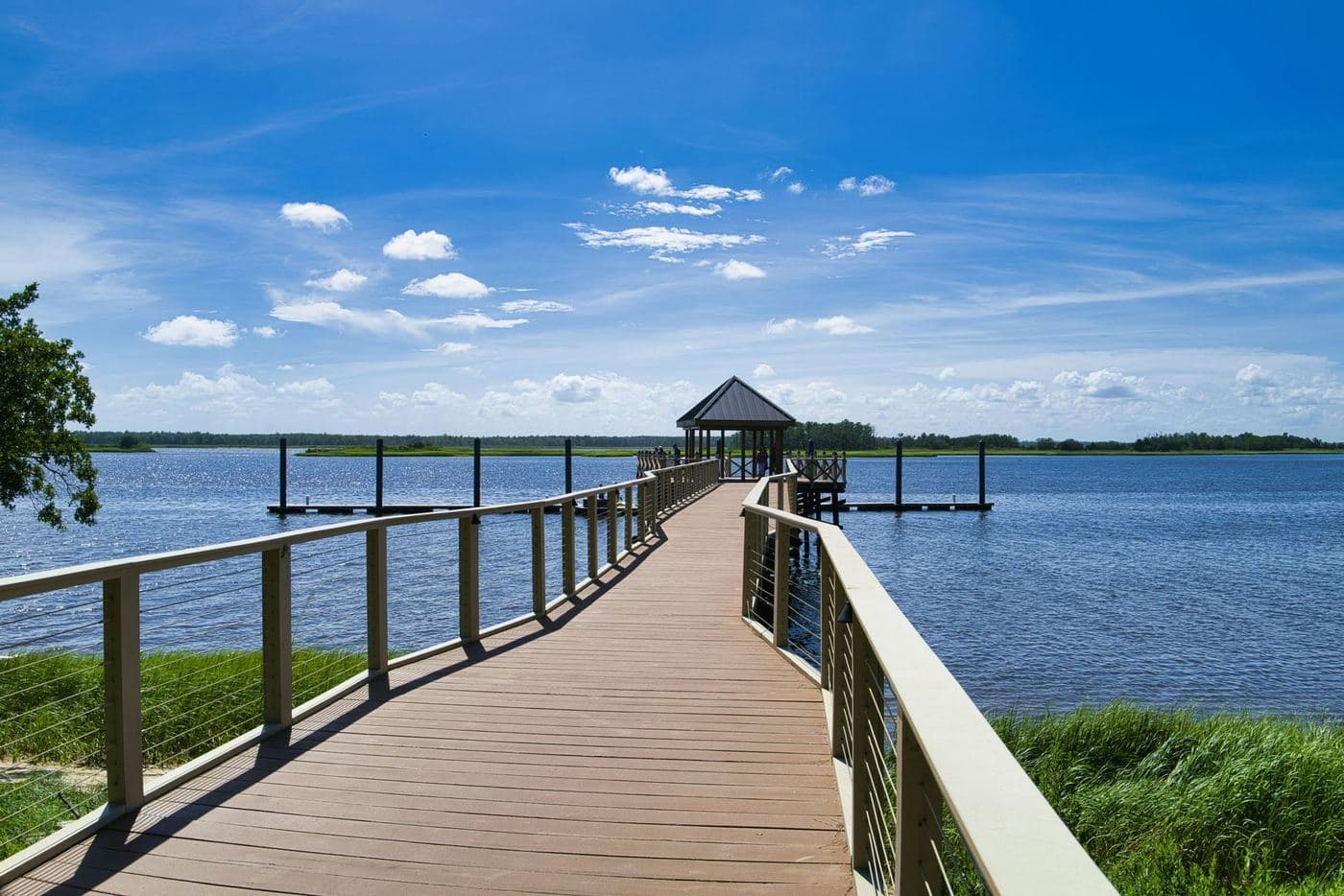 A long Mariner-built dock walkway with a covered platform reaching into open water under a blue sky