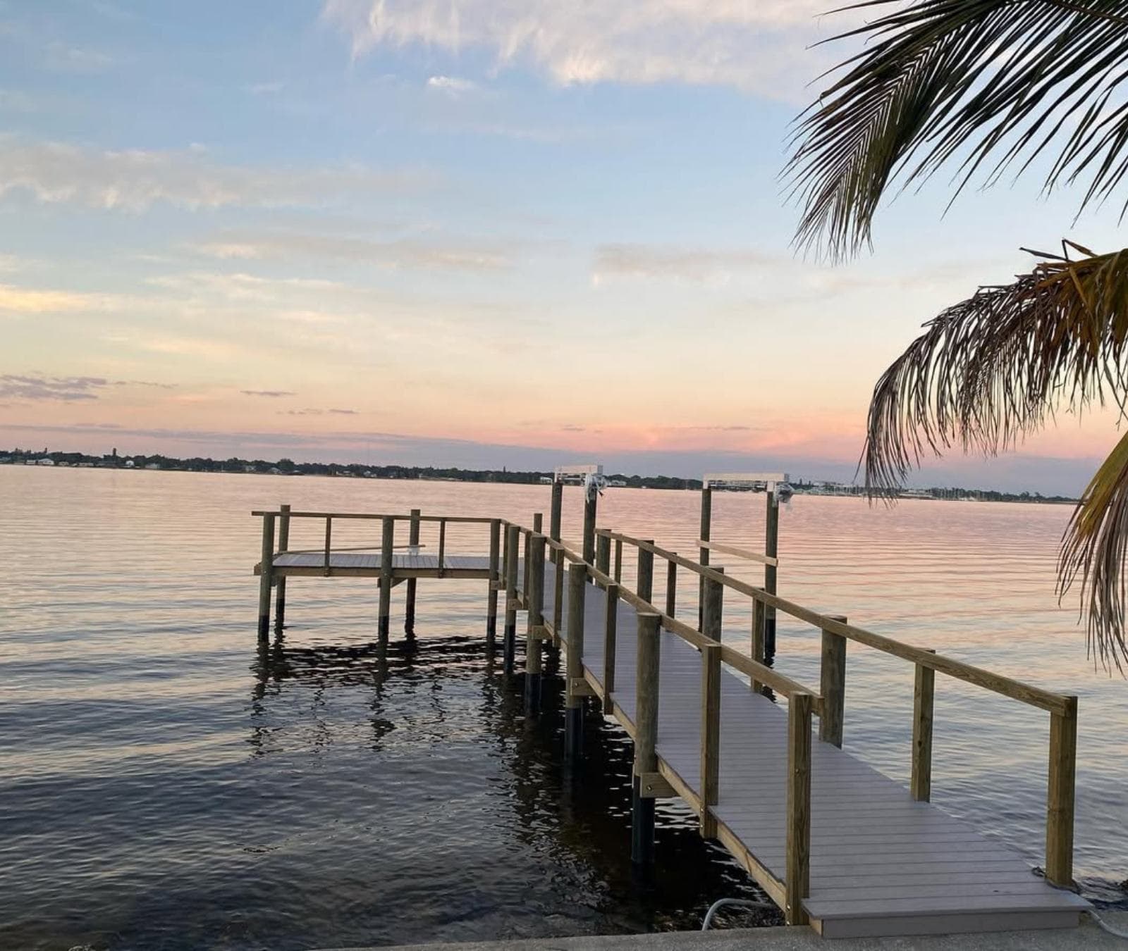 A Mariner-built dock and walkway reaching out over calm open water at sunset in Southwest Florida
